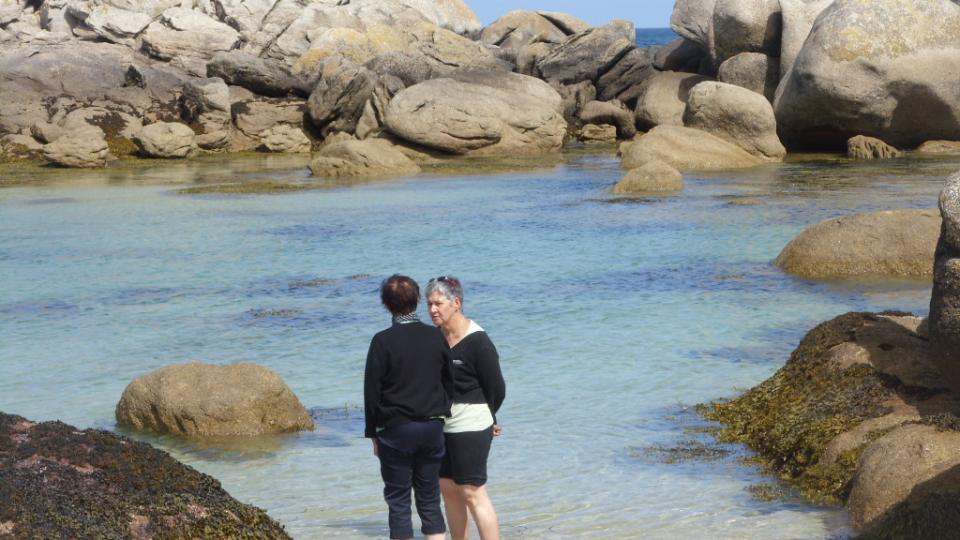 2 personnes debout conversant, dans une crique